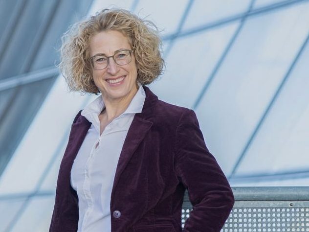 Lächelnde Silke mit blonder Lockenfrisur, Jeansjacke und großer Schützenfest-Kette um den Hals.